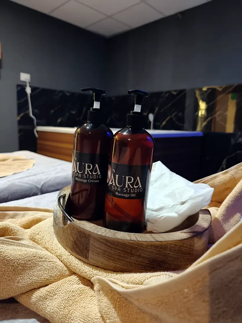 Aura massage cream and massage oil in a wooden tray
